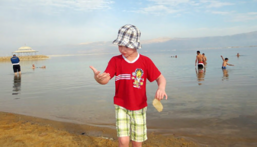 Vojta na pláži Mrtvého moře, v ruce drží solnou krustu (foto: Zuzana N.)